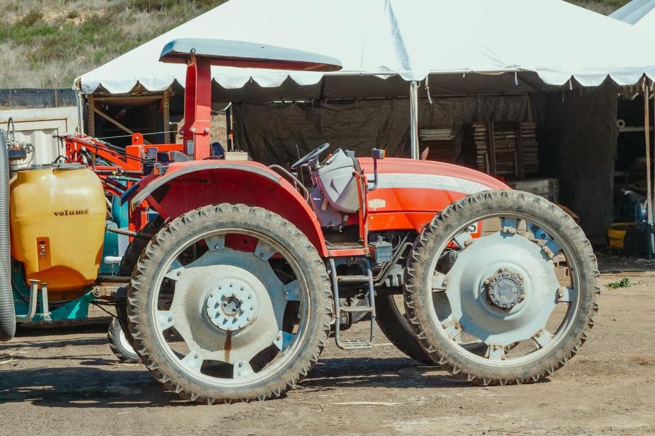 Röd McCormick-traktor med smala hjul på en lantbruksauktion.