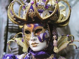Närbild på en elegant venetiansk maskeradmask i lila och guld.