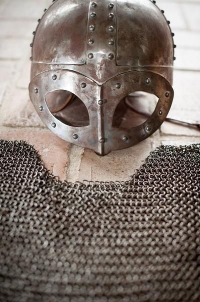Nitförsedd metallhjälm utan horn, med ringbrynja framför sig